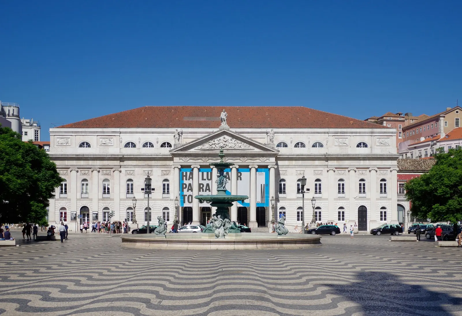 Neoklassizistische Fassade des Nationaltheaters D. Maria II und Rossio-Brunnen, aufgenommen 2018